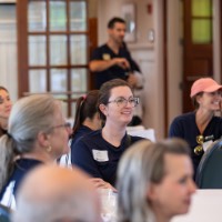 Table of GVSU Alumni listen to speaker